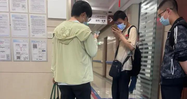 韋神被2小夥拉去看牙，背雙肩包踩大拖鞋不修邊幅，手機貼臉上看
