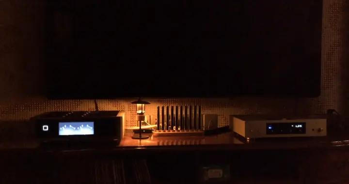 溫馨的客廳，夜晚的溫暖時光，電視旁的小燈點綴着靜謐的夜晚。